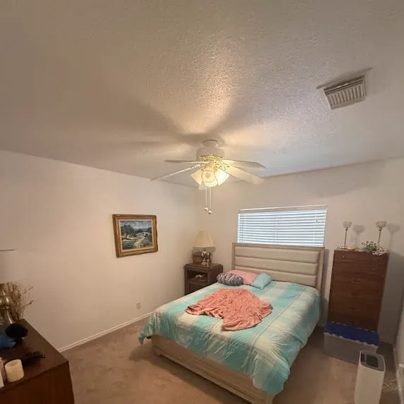 Bedroom with light beige painted walls, a white ceiling, and white window trim