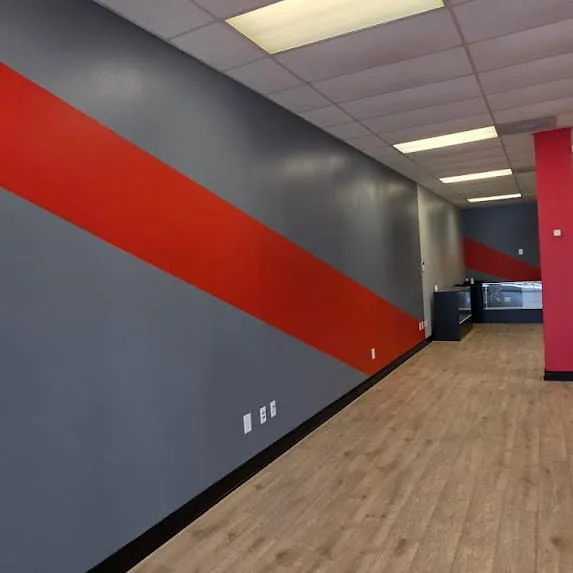Commercial hallway with gray painted walls and a bold red diagonal accent stripe