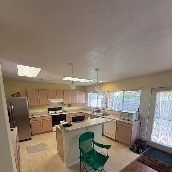 Kitchen with pale yellow painted walls, a white ceiling, and natural wood cabinets
