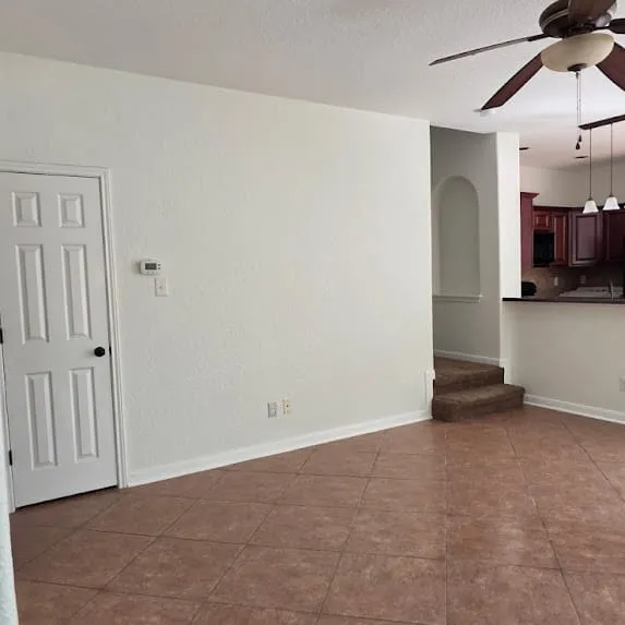 Living room with off-white painted walls, white baseboards, and white door trim