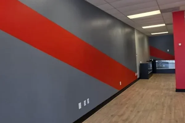 Commercial hallway with gray painted walls and a bold red diagonal accent stripe