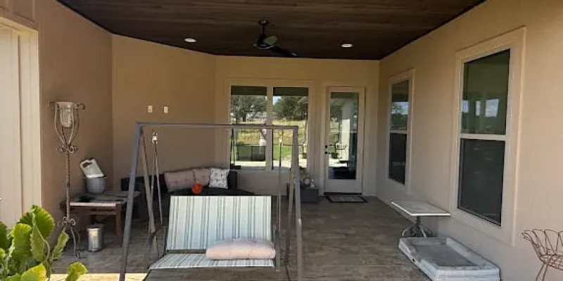 Covered patio with beige exterior walls, a wood ceiling, and a porch swing