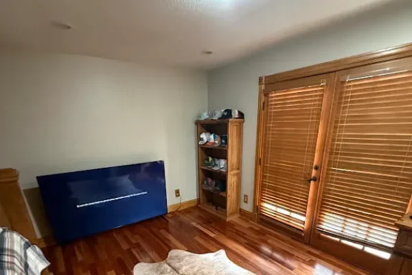 Room with light neutral painted walls and natural wood trim around French doors